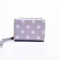 Short purple zip-around wallet featuring white star patterns and a matching wrist strap - Purple