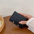 Portafoglio corto da donna nero in pelle coccodrillo con fibbia dorata - Nero