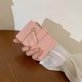 Pink minimalist women's bi-fold wallet featuring a gold zipper pocket and snap strap - Pink