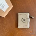 Portafoglio corto vintage in beige con motivi traforati e chiusura a margherita - Grigio