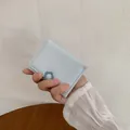 Slim light blue tri-fold mini wallet for women featuring a dark blue floral clasp detail - Light Blue
