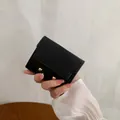 Short black bifold wallet in cross-grain leather with elegant gold bead closures - Black