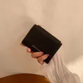 Portamonete nero trapuntato in ecopelle con cerniera dorata e logo minimalista - Nero