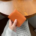 Portafoglio arancione in pelle con grana litchi, zip dorata e slot per carte frontale - Arancione