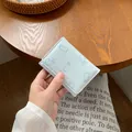 Piccolo portafoglio azzurro a tre ante con stampe di conigli e scritte dorate - Blu Pallido