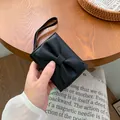 Portafoglio corto nero da donna con fiocco, trama in pelle e cerniera in metallo dorato - Nero