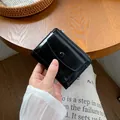 Compact black glossy faux leather mini wallet featuring metal zipper and snap button flap - Black