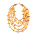 Detail van een vijflaagse kralenketting met gele buisjes en perzikkleurige schijfkralen - Oranje