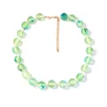 Detail van een handgemaakte kralenketting met lichtgroene kralen en gouden karabijnsluiting - Groen