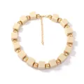Détail d'un collier bohème fait main avec cubes beiges mats et perles dorées - Milky blanc