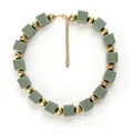 Détail de perles cubiques mates vertes et sphères dorées sur un collier bohème - Vert olive