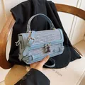 Light blue woven leather crossbody bag featuring an ornate heart-shaped metal buckle - Blue
