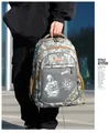 Detail eines Pixel-Camouflage-Rucksacks mit M416-Aufdruck und seitlicher Netztasche - Grau