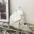 White washed canvas backpack featuring multi-pocket design and adjustable straps - White