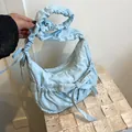 Light blue quilted nylon crossbody bag featuring stylish pleated bows and drawstring - Blue