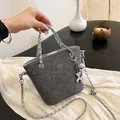 Borsa a secchiello in denim grigio con tracolla a catena d'argento e ciondolo - Nero Denim