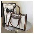 Bolso tote de lona en contraste con ribete de cuero marrón y asas dobles sobre mesa - Marrón