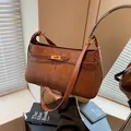 Vintage dunkelbraune Wildleder Schultertasche mit goldener Schnalle bei warmem Morgenlicht - Braun