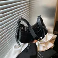 Chic black patent leather underarm bag with silver eyelet studs and buckle details - Black