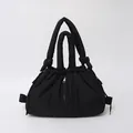 Black puffer tote bag with quilted texture, drawstring closure and vertical zipper detail - Black