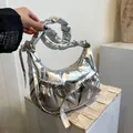 Silver metallic puffer shoulder bag with ruched strap and bow detail in a minimalist setting - Silver