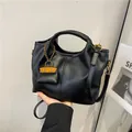 Elegante schwarze Eimertasche aus Leder mit goldenem Anhänger und Schultergurt - Schwarz