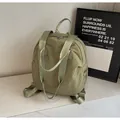Vista de detalle de mochila de lona verde oliva con textura de nailon suave y las asas - Verde