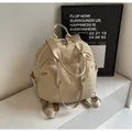 Detalle de la suave textura arrugada y el bolsillo lateral con cordón en la mochila beige - Caqui