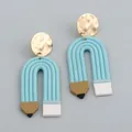 Macro shot of colorful handmade clay pencil earrings with gold hammered metal studs - Sky Blue