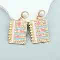 Close-up of heart notebook earrings with pink enamel and small pearls detail - Pink Heart