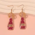Pink rhinestone champagne bottle drop earrings with CHEERS text and pearl accents - Colorful Stone Style