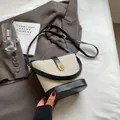 Elegante bolso de lona en crema y negro con cierre dorado y correa de cuero ajustable - Negro