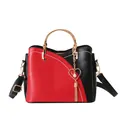 Chic red and black patchwork bucket bag with golden top handle and heart tassel detail - Red