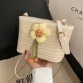 Beigefarbene Stroh-Eimertasche mit Blumenakzenten und weißem Lederriemen - Weiße kleine Blumen