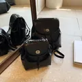 Glänzender schwarzer Mini-Rucksack in zwei Größen mit Metallkette und Drehverschluss - Schwarz Klein
