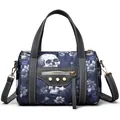 Macro shot of skull floral fabric texture and golden rivet details on the handbag - Blue