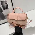 Detail van roze leer en beige canvas stiksels op een stijlvolle crossbody tas - Roze & Beige