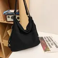 Minimalistische zwarte hobo-schoudertas van canvas met een ruim voorvak voor dames - Zwart