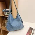Lichtblauwe denim shopper met verstelbare banden in een casual lifestyle omgeving - Lichtblauw