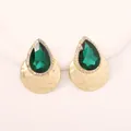 Detail of pear-cut emerald green gemstone earrings with sparkling halo and gold hammer texture - Green