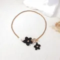Elegant gold flat snake chain necklace with black flower charms and OT toggle clasp - Necklace / Black