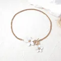 Elegant gold snake chain necklace with white flower charms and stylish OT toggle clasp - Necklace / White