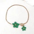 Detail of elegant gold flat snake chain necklace with green flower pendant and toggle clasp - Necklace / Green