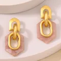 Golden geometric earrings with pink marble resin hexagons on minimalist beige pedestal - Pink Hexagon