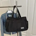 Large black nylon tote bag with fashion tag and side pockets for daily commuting - Black