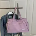 Large lavender nylon tote bag with a Fashion patch on the front hanging on a hanger - Purple