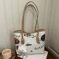 Borsa tote in tela bianca con grafiche astronauta e manici marroni su tavolo - Con Ciondolo / Bianco