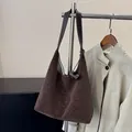 Dunkelbraune Hobo-Tasche aus Leder im Retro-Stil mit weißen Ziernähten und Textur - Kaffeebraun