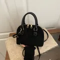 Black vintage textured shell bag with gold hardware and top handle for women - Black