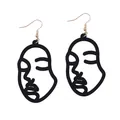 Detail showing minimalist laser cut wooden earrings with abstract black face profiles - Black